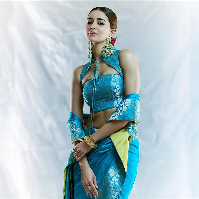 অনন্যা বেনারসির শাড়ি-গাউনের মাধ্যমে ঐতিহ্যকে নতুনভাবে উপস্থাপন করেছেন। লুকের কেন্দ্রবিন্দু হলো স্টানিং টারকোয়াইজ-নীল বেনারসি শাড়ি। ফেব্রিকে রয়েছে রাজকীয় জারি মোটিফের সঙ্গে গোল্ডেন ফুলেল প্যাটার্ন। তবে সত্যিই এই লুককে আলাদা করেছে ড্রেপিং স্টাইল বা শাড়ি পরার ধরন। 