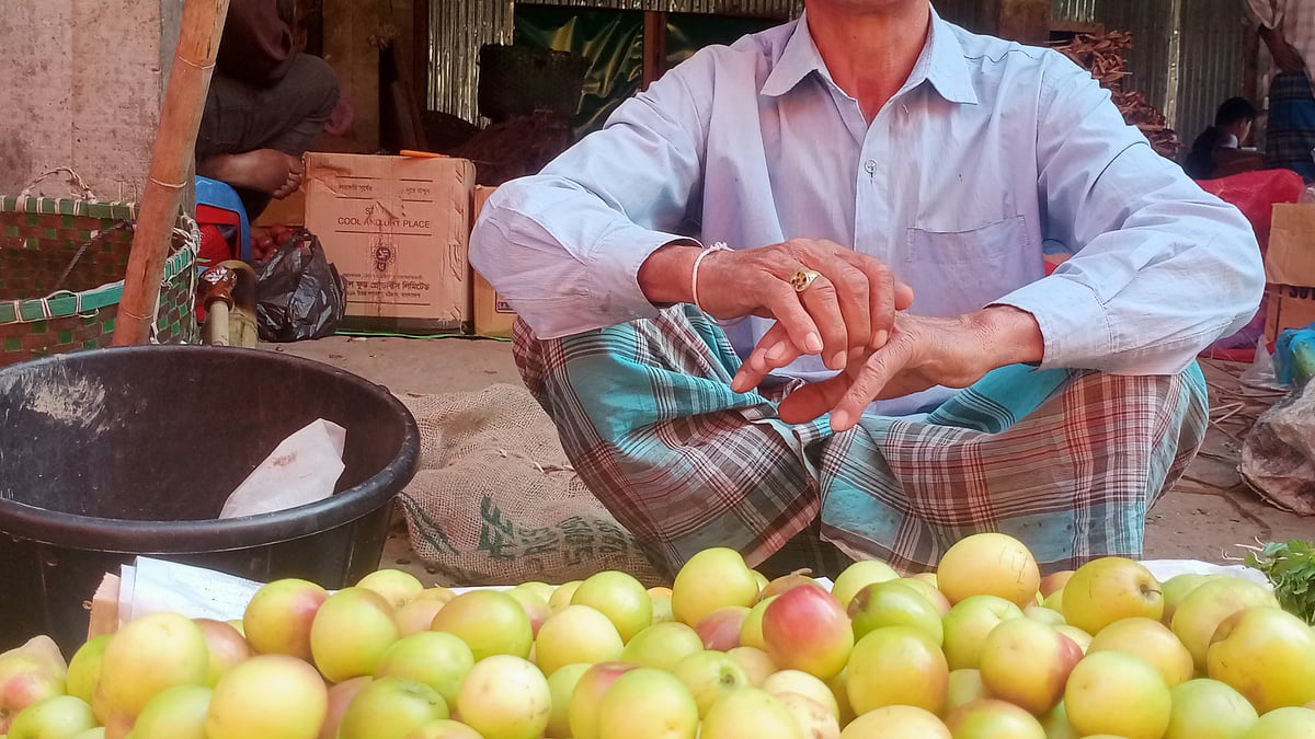 বনরূপা বাজারে ‘ভারত সুন্দরী’ কুলের পসরা সাজিয়ে হাসিমুখে বসে আছেন এক বিক্রেতা