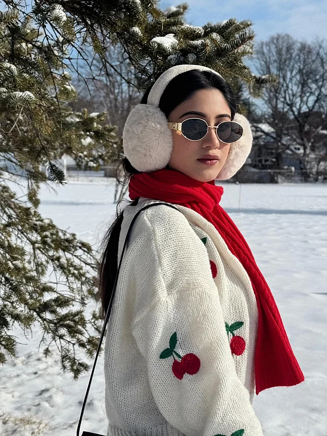 সাদা ওলেন সোয়েটারটি পুরো লুকের কেন্দ্রবিন্দু। সোয়েটারের গায়ে ছোট ছোট লাল চেরি মোটিফ শীতের একঘেয়েমি ভেঙে দিয়েছে প্রাণবন্ত ছোঁয়ায়। ঢিলেঢালা স্লিভ আর নরম টেক্সচার এই পোশাককে করে তুলেছে আরামদায়ক, আবার একই সঙ্গে স্টাইলিশ।