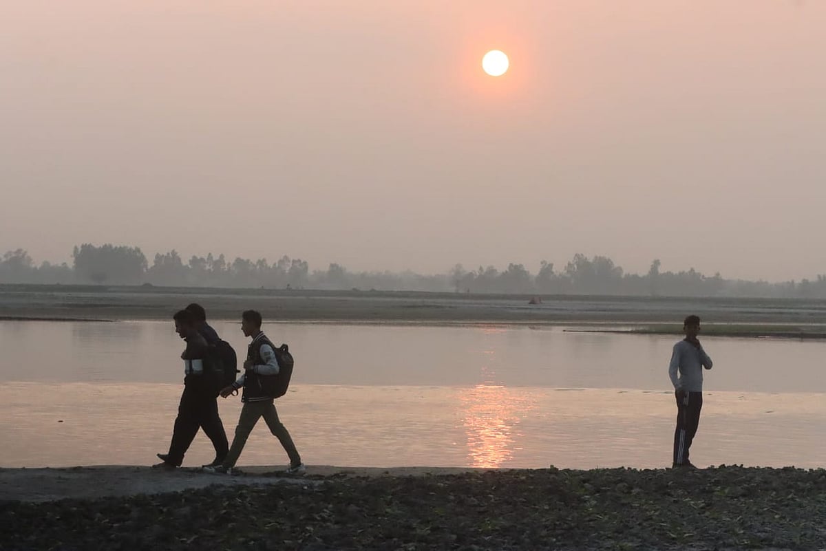 নদীর তীরে খোলা পরিবেশ উপভোগ করতে আসা কয়েকজন 
