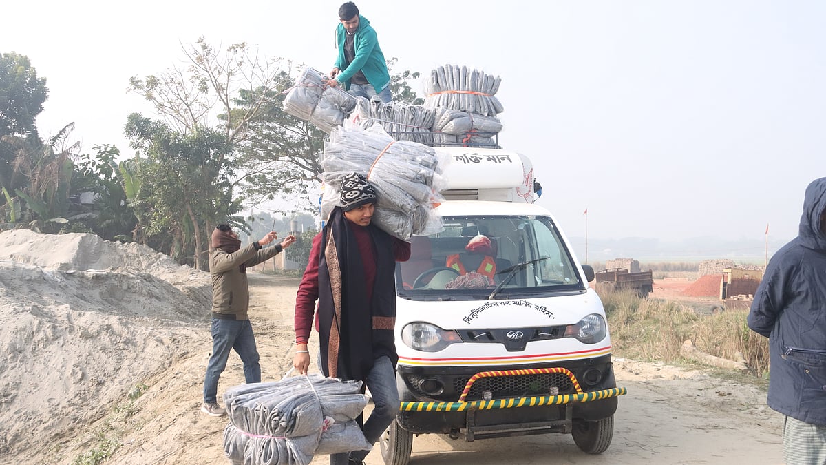 কাঁধে করে কম্বল ট্রলারে তুলছেন প্রথম আলো বন্ধুসভার স্বেচ্ছাসেবকেরা