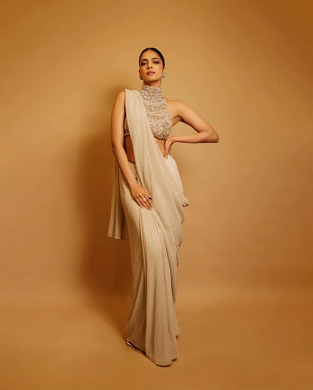 সাদা সিল্ক শাড়িতে লাল-সোনালি করসেট ব্লাউজে তিনি যোগ করেছেন আধুনিক এজ, যেখানে ঐতিহ্য আর ফ্যাশন একে অন্যকে ছাপিয়ে যায় না, বরং পরিপূরক হয়ে ওঠে। 