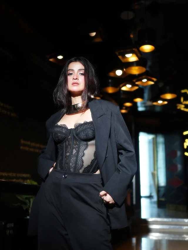 কালো শিইয়ার ফেব্রিকের করসেট টপ আর সেই সঙ্গে হাই ওয়েস্টেড ম্যাচিং ট্রাউজার্স ও ব্লেজারে আবেদন ছড়াচ্ছেন বং বার্বি