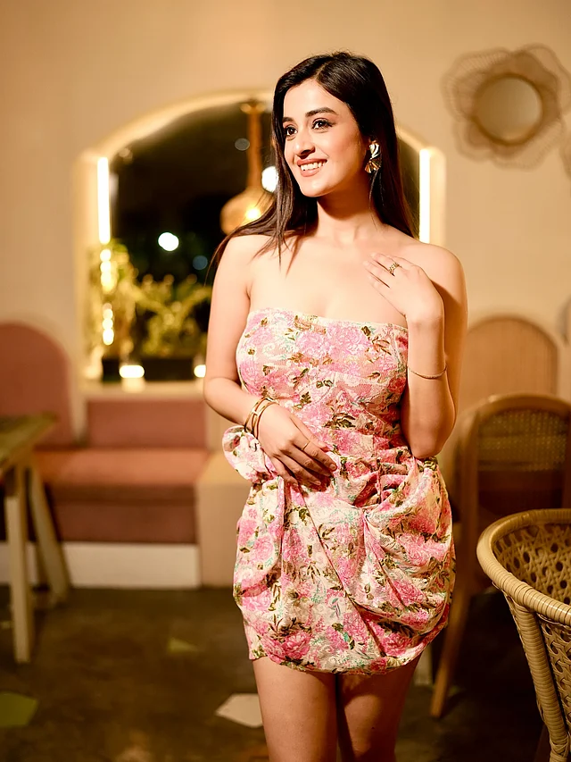 এই লুকে দর্শনা পরেছেন ফুলেল প্রিন্টের গ্যাদারড ফেব্রিক ডিজাইনের গোলাপি  স্ট্র্যাপলেস মিনিড্রেস