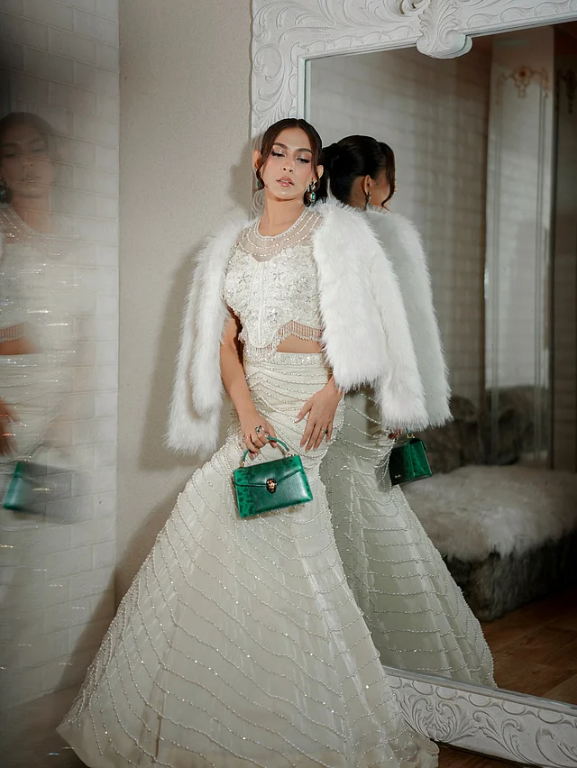 সিকুইন আর বিডসের কাজ করা টু পিস মারমেইড কাট পোশাকের সঙ্গে অভিনেত্রী লেয়ার করেছেন সাদা ফার জ্যাকেট । সঙ্গে নিয়েছেন পান্না সবুজ হ্যান্ড ব্যাগ