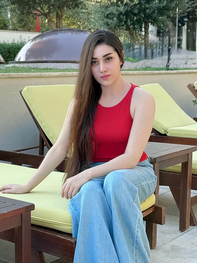 এখানে লাল ট্যাংক টপ আর নীল ফ্লেয়ার জিনসে দেখা যাচ্ছে রিয়াকে