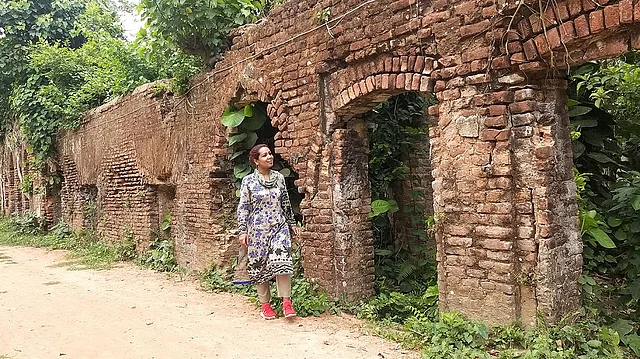 মেঠো পথের পাশে বাড়ির ধবংসাবশেষে দাঁড়িয়ে লেখক