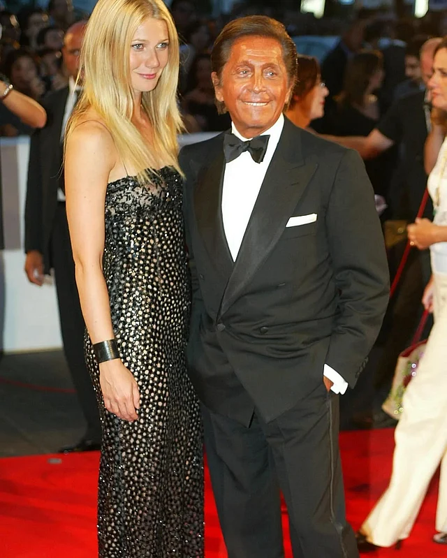 ড্যাপার লুকের ভ্যালেন্তিনোর সঙ্গে তাঁর ডিজাইন করা নুডল স্ট্র্যাপের সিকুইন কলাম ড্রেসে পোজ দিয়েছেন গিনেথ প্যালট্রো