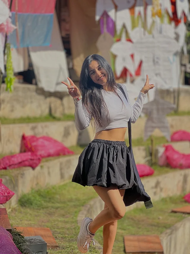  এই লুকটি একদমই প্রাণবন্ত ও ইয়ুথ ফুল। সাদা ফুল-স্লিভ ক্রপ টপের সঙ্গে কালো মিনি ফ্লেয়ার্ড স্কার্টের এই কম্বিনেশন ক্ল্যাসিক ।পায়ে সাদা স্নিকার্স পুরো লুকটাকে দিয়েছে স্ট্রিট-স্টাইলের ছোঁয়া
