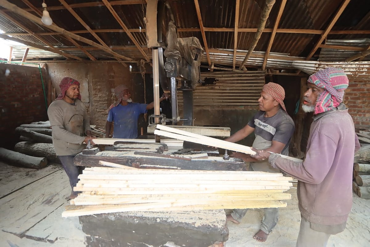 স–মিল বা করাতকলে ফেস্টুন বানাতে কাঠ কাটছেন শ্রমিকেরা 