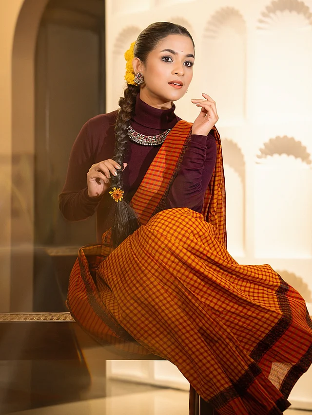 এই লুকে ধরা পড়েছে দেশি আমেজ আর পরিমিত আভিজাত্যের ছোঁয়া। লাল-কমলা রঙের ঐতিহ্যবাহী গামছা শাড়িতে আধুনিক স্টাইলিংয়ের নিখুঁত মেলবন্ধন তৈরি করেছেন সাদিয়া