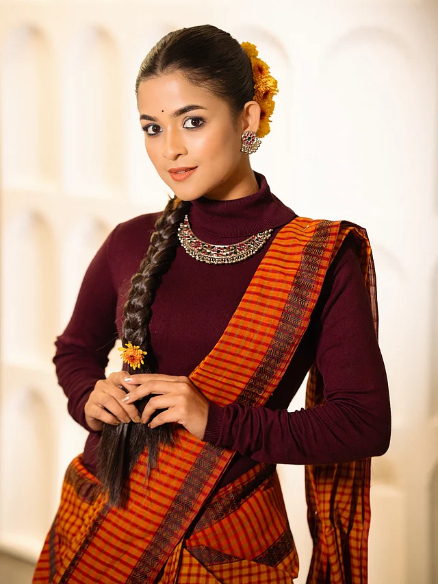 শাড়ির সঙ্গে কনট্রাস্ট তৈরি করেছে মেরুন রঙের হাই নেক, ফুল স্লিভ ব্লাউজ। শাড়ির সঙ্গে মোনোক্রম টপে বেশ এলিগ্যান্ট লাগছে অভিনেত্রীকে