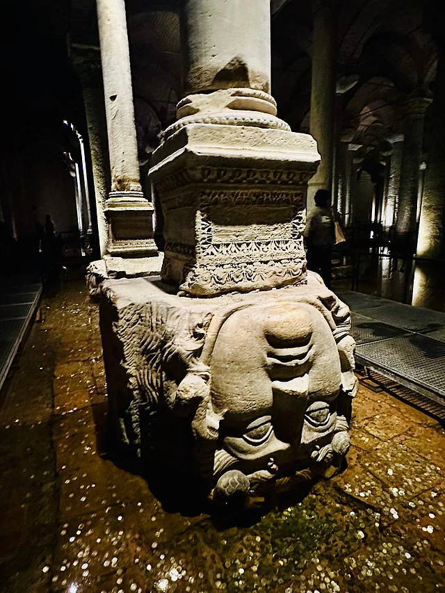 ছবি ১: ব্যাসিলিকা সিস্ট্রানের অন্ধকার জলে আধডোবা পাথরের স্তম্ভভিত্তিতে শুয়ে আছে মেডুসার মাথা—একটি পাশ ফিরে, আরেকটি উল্টো করে বসানো।
