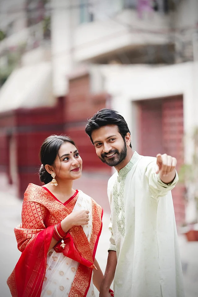 লাল পাড়ের সাদা শাড়ি ও সাদা পাঞ্জাবিতে বাঙালি সাজে দেখা যাচ্ছে এই জুটিকে