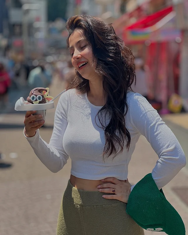 পুপ আইসক্রিম হাতে মনামী। পরনে সাদা ফুলস্লিভ ক্রপ টপ আর হাই ওয়েস্ট স্কার্ট। সঙ্গে সবুজ সামার টুপি