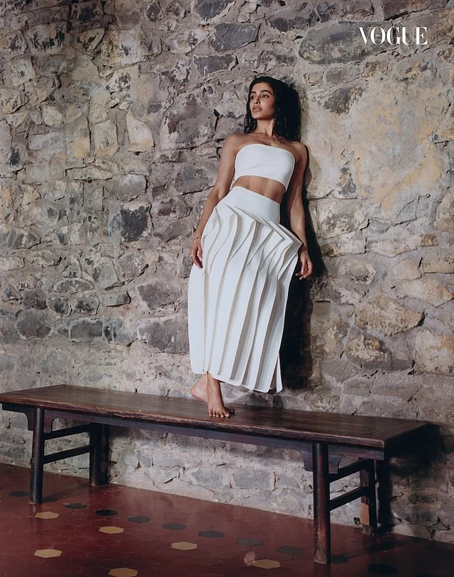 সাদা স্ট্র্যাপলেস টপের সঙ্গে মিডি দৈর্ঘ্যের এই স্কার্টে আছে চোখধাঁধানো ড্রেপড প্যানেল। 