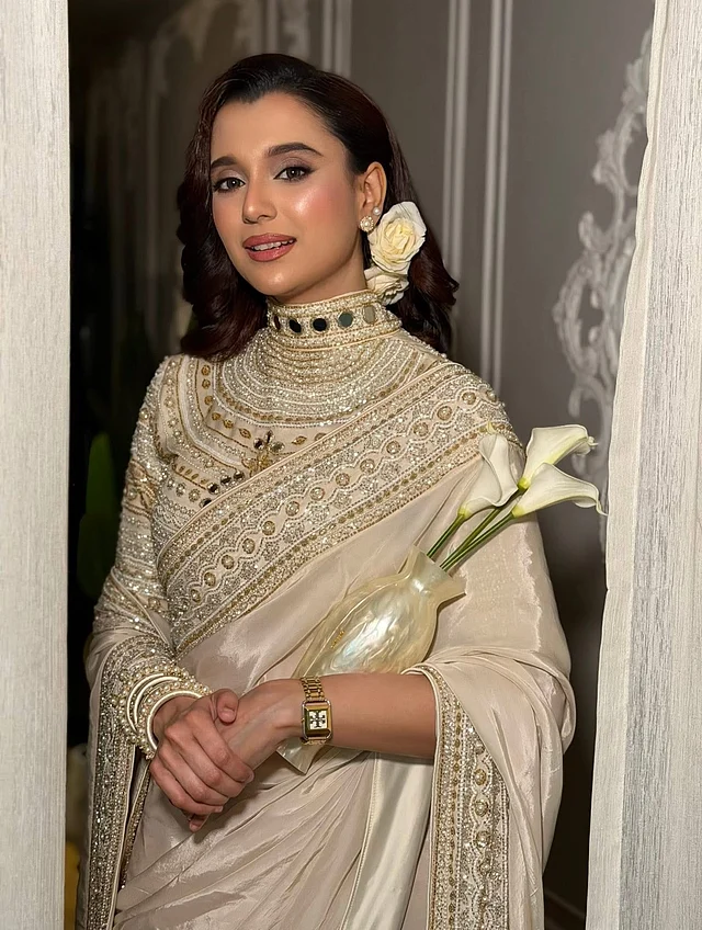 তবে এই লুকের সবচেয়ে ব্যতিক্রমী আকর্ষণ ছিল ফুলদানী আকৃতির পার্স। মুক্তার মতো উজ্জ্বল একটি ফুলদানীর ভেতরে রাখা সাদা ক্যালা লিলি—যেন ব্যাগ নয়, হাতে ধরা এক টুকরো শিল্প।তবে এই ব্যাগ কেবল স্টাইলের জন্য নয়; ব্যবহারেও সম্পূর্ণ কার্যকর। প্রচলিত ক্লাচ বা পার্সের বাইরে এমন সৃজনশীল অ্যাক্সেসরিই সাবিলার লুককে সামাজিক মাধ্যমে মুহূর্তেই ভাইরাল করে তুলেছে। 