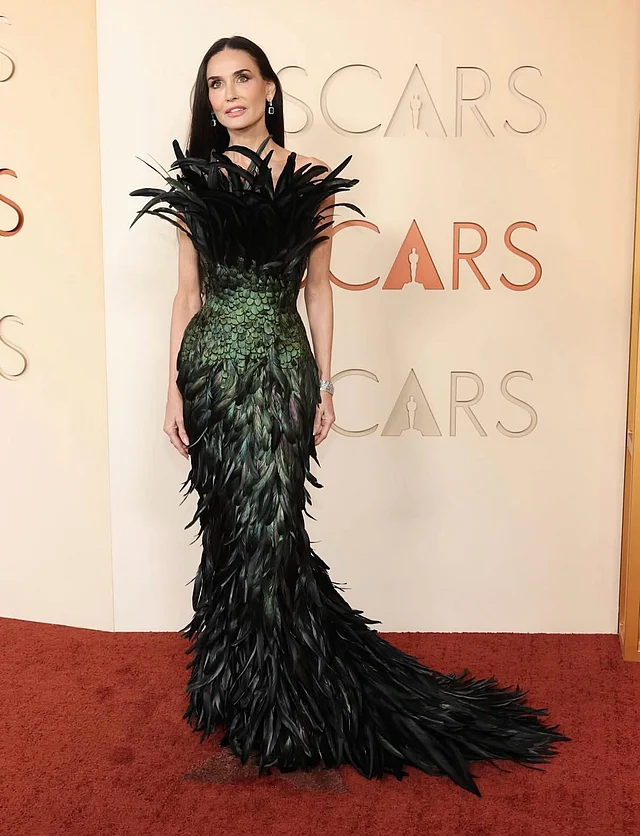 কাস্টম গুচি গাউনে টাইমলেস বিউটি ডেমি মুর। এখানেও স্ট্র্যাপলেস গাউনে ফেদার ডিটেইলিং। তবে রং কালো-সবুজ