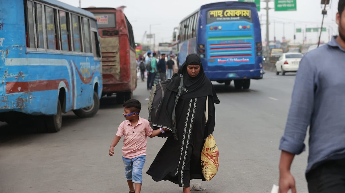 সন্তানের হাত ধরে গাবতলী বাস টার্মিনালের পথে এই মা