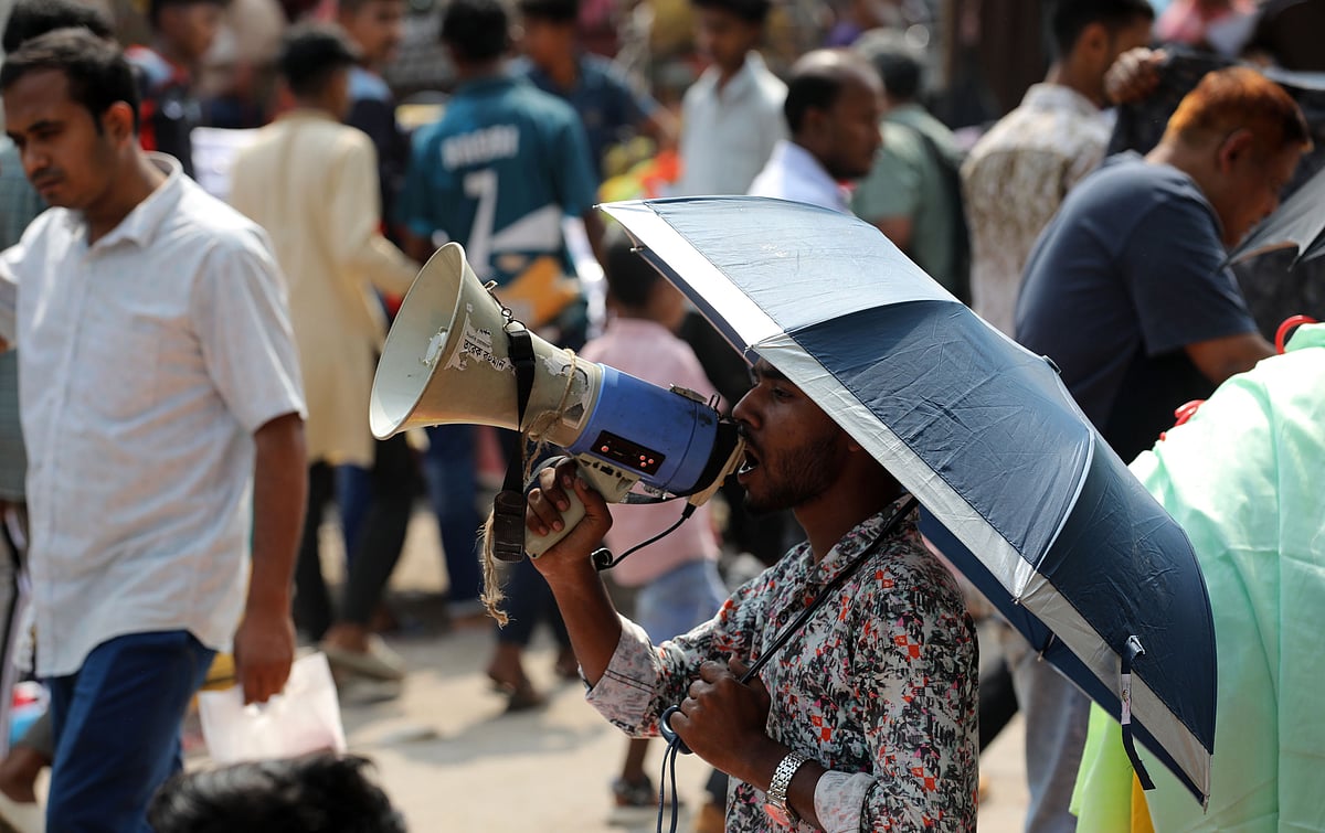 হ্যান্ডমাইকে ডেকে ক্রেতা আকর্ষণ করছেন এক বিক্রেতা 