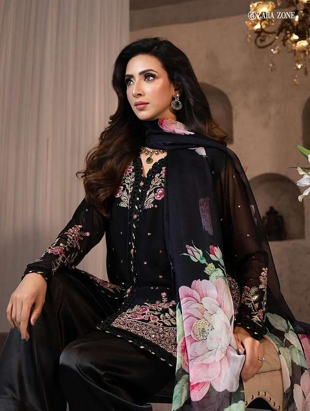 এই লুকে মীমকে দেখা যাচ্ছে ব্ল্যাক ফারসি সালোয়ার স্যুটে। কামিজ জুড়ে ফুটে উঠেছে নিখুঁত ফ্লোরাল এমব্রয়ডারি। এর সঙ্গে ম্যাচ করা ওয়াইড-লেগ প্যান্ট পরেছেন। লুকটি সম্পূর্ণ করেছে বড় ফ্লোরাল মোটিফের ডিজিটাল-প্রিন্টেড শিফন ওড়না। পোশাকের গোলাপি ফুলের সঙ্গে মিল রেখে তিনি বেছে নিয়েছেন গোলাপি আভার মেকআপ, আর সঙ্গে রয়েছে সবুজ পাথরের জুয়েলারি, যা পুরো লুকে কনট্রাস্ট তৈরি করে আরও আকর্ষণীয় করে তুলেছে।