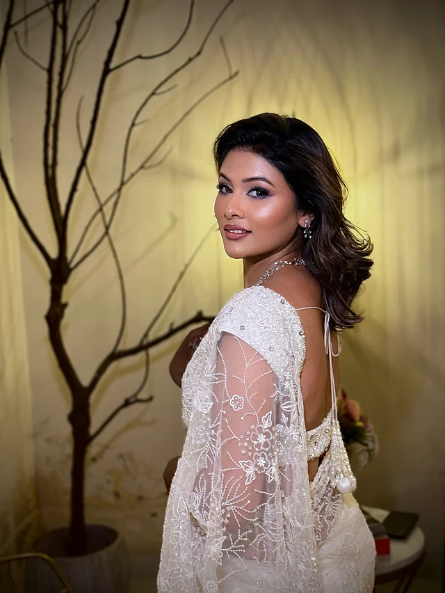  টয়া এই শাড়ির সঙ্গে সফট গ্ল্যাম মেকআপে সেজেছেন। ডিউই ফিনিশ স্কিন, স্মোকি আইস, আর ন্যুড ব্রাউনিশ লিপস্টিক পুরো লুকের সঙ্গে নিখুঁতভাবে মানিয়েছে