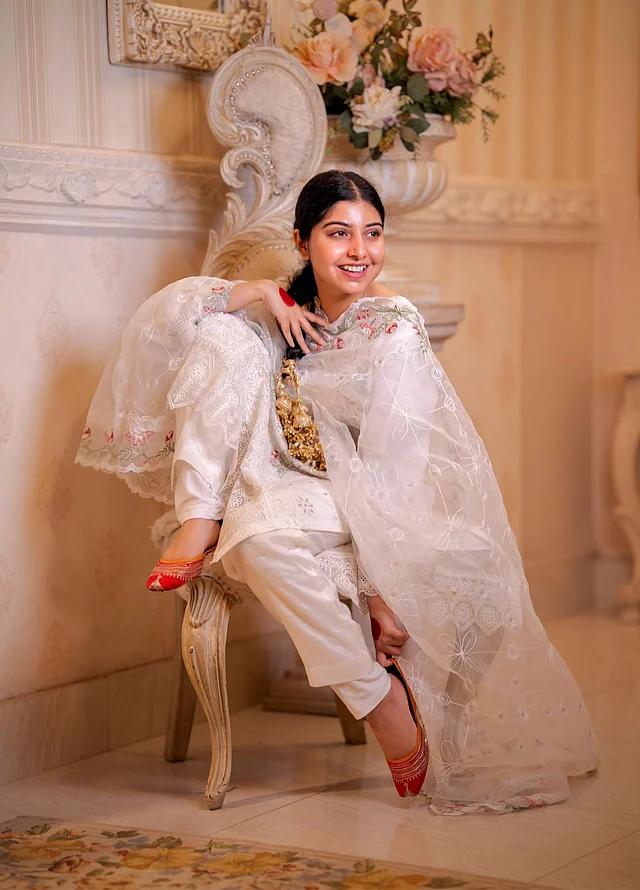 সাদা অরগাঞ্জার স্নিগ্ধ সালওয়ার কামিজের লুকে সোনালি ট্যাসেলের বেনীর পরিপাটি হেয়ারস্টাইল আর লাল জুতিতে পড়শী