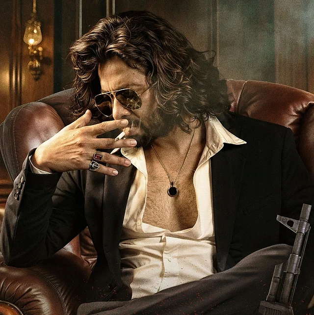 তুফান সিনেমার লম্বা চুল, দাড়ি-গোঁফ আর রেট্রো শার্টের স্যুটেড লুক। সঙ্গে আছে সানগ্লাস আর পেন্ডেন্ট