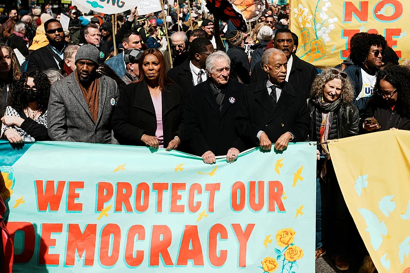 ট্রাম্পবিরোধী ‘নো কিংস’ বিক্ষোভে নেমেছেন বিখ্যাত হলিউড অভিনেতা রবার্ট ডি নিরো। তাঁর সঙ্গে বিক্ষোভে যোগ দিয়েছেন নিউইয়র্কের অ্যাটর্নি জেনারেল লেতিশিয়া জেমস, প্রবীণ রাজনীতিক আল শার্পটন প্রমুখ। ২৮ মার্চ ২০২৬, নিউইয়র্ক