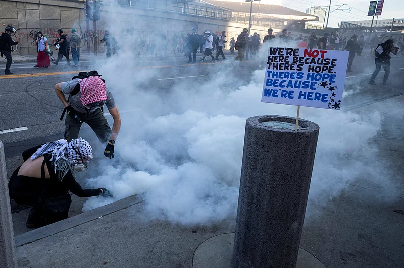 পুলিশের কর্মকর্তারা ফেডারেল ভবনের বাইরে টিয়ার গ্যাস নিক্ষেপ করলে বিক্ষোভকারীরা সেটা সরানোর চেষ্টা করছেন। লস অ্যাঞ্জেলেস, ২৮ মার্চ