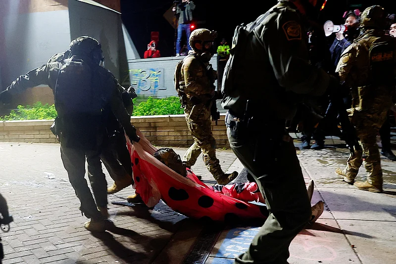 এক বিক্ষোভকারীকে আটক করে নিয়ে যাচ্ছেন আইনশৃঙ্খলা রক্ষাকারী বাহিনীর সদস্যরা। ওরেগন, ২৮ মার্চ