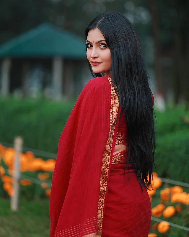 সোনালি পাড়ের লাল টুকটুকে শাড়িতে আকর্ষণীয় লাগছে তাঁকে 