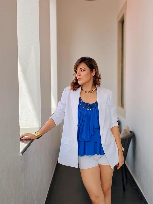 রয়্যাল ব্লু রঙের টিয়ার্ড টপ, স্ট্রাকচার্ড হোয়াইট ব্লেজারের সঙ্গে বটমে মিনিমাল হোয়াইট শর্টস পরেছেন স্টাইলিশ এই তারকা। জুয়েলারি হিসেবে বেছে নিয়েছেন গোল্ড-টোন নেকপিস আর কাফ ব্রেসলেট 