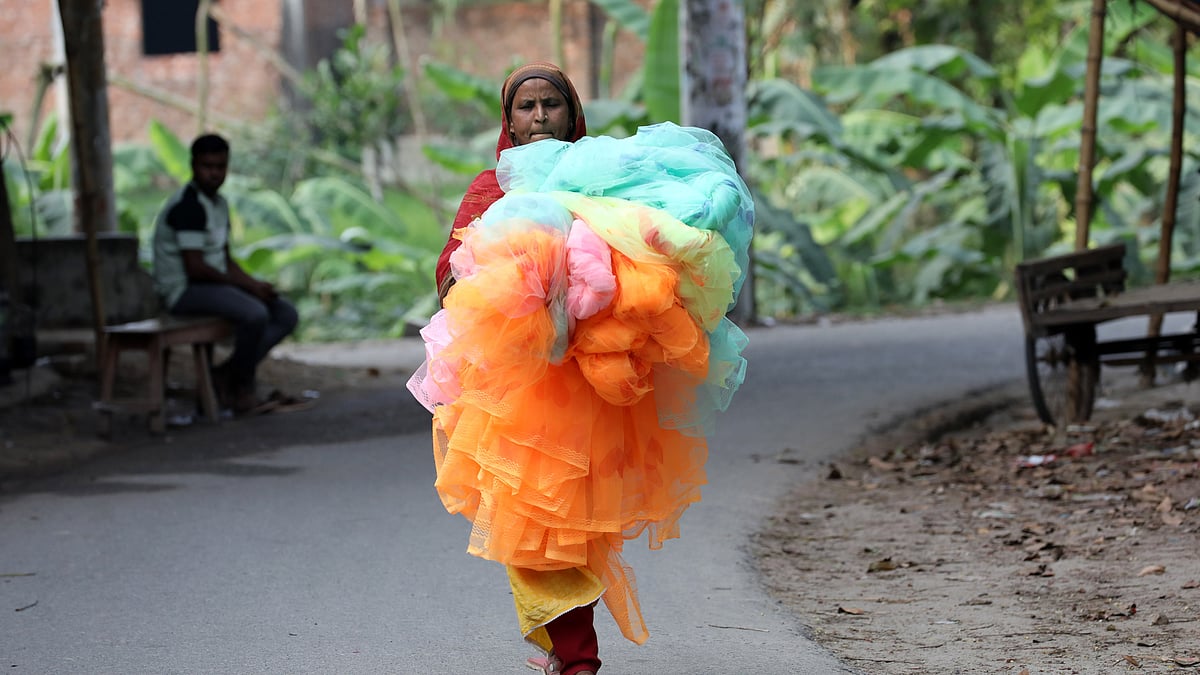 নানা রঙের মশারি নিয়ে যাচ্ছেন এই নারী
