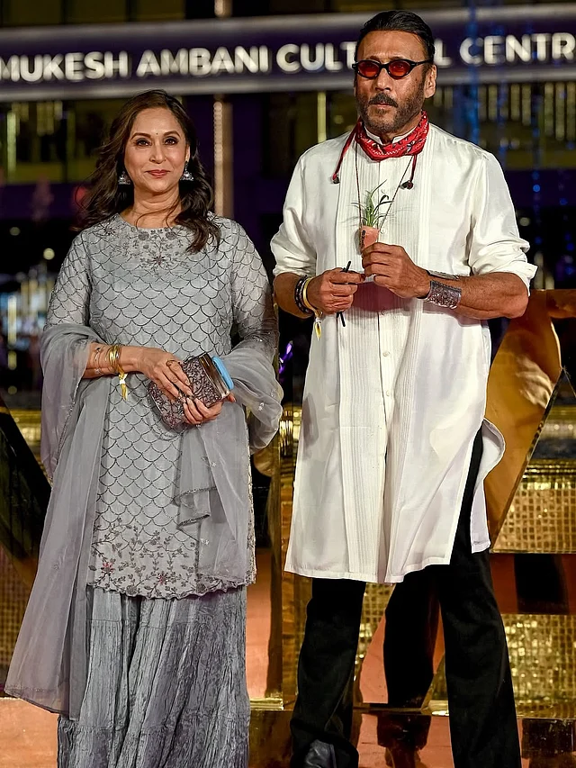 জ্যাকি শ্রফ পরেছেন সাদা পাঞ্জাবি কালো প্যান্ট। গলায় সবসময়ের মতো ছোট গাছ ঝুলানো। স্ত্রী আয়শা পরেছেন রূপালি শারারা কামিজ 