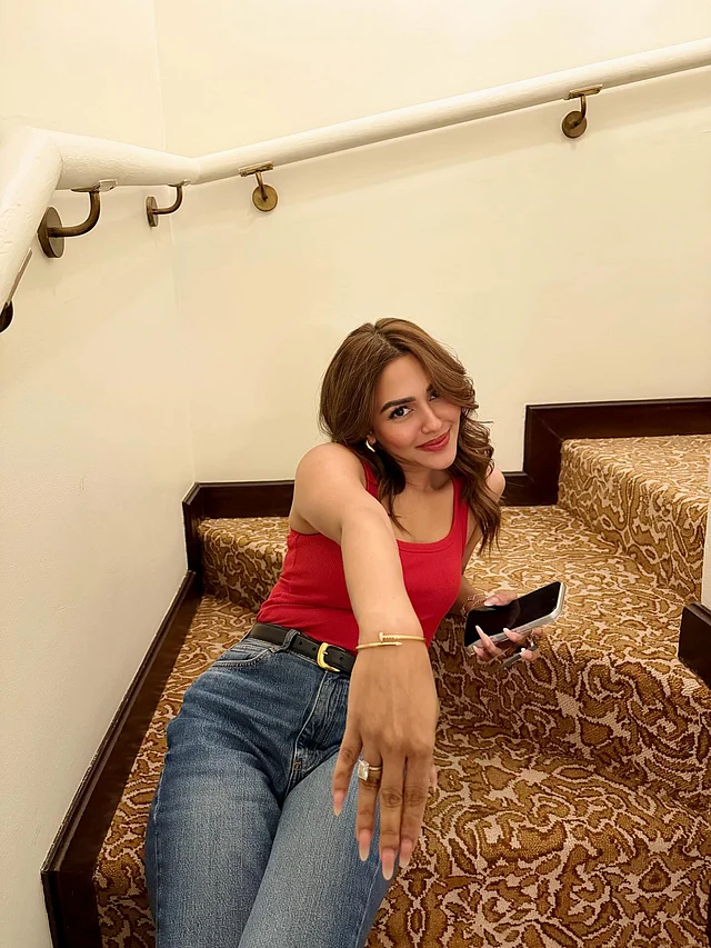 এখানে তিনি পরেছেন লাল ট্যাংক টপ ও নীল ক্ল্যাসিক ওয়াশের হাই ওইয়েস্ট জিন্স। হাতের আংটি দেখাচ্ছেন তিনি 