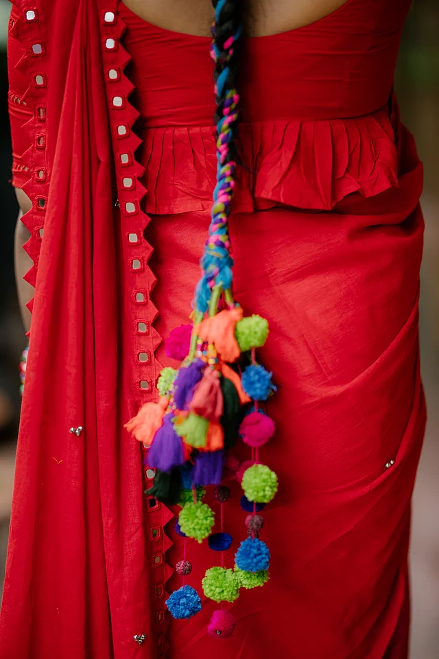 শাড়ির সঙ্গে পাল্লা দিচ্ছে তাসা-র চুলের ফিতা আর হালের ক্রেজ হেয়ার স্ট্রিংস। কাপড়ের লম্বা ঝালরে বহু রঙিন ট্যাসেল ও পমপম