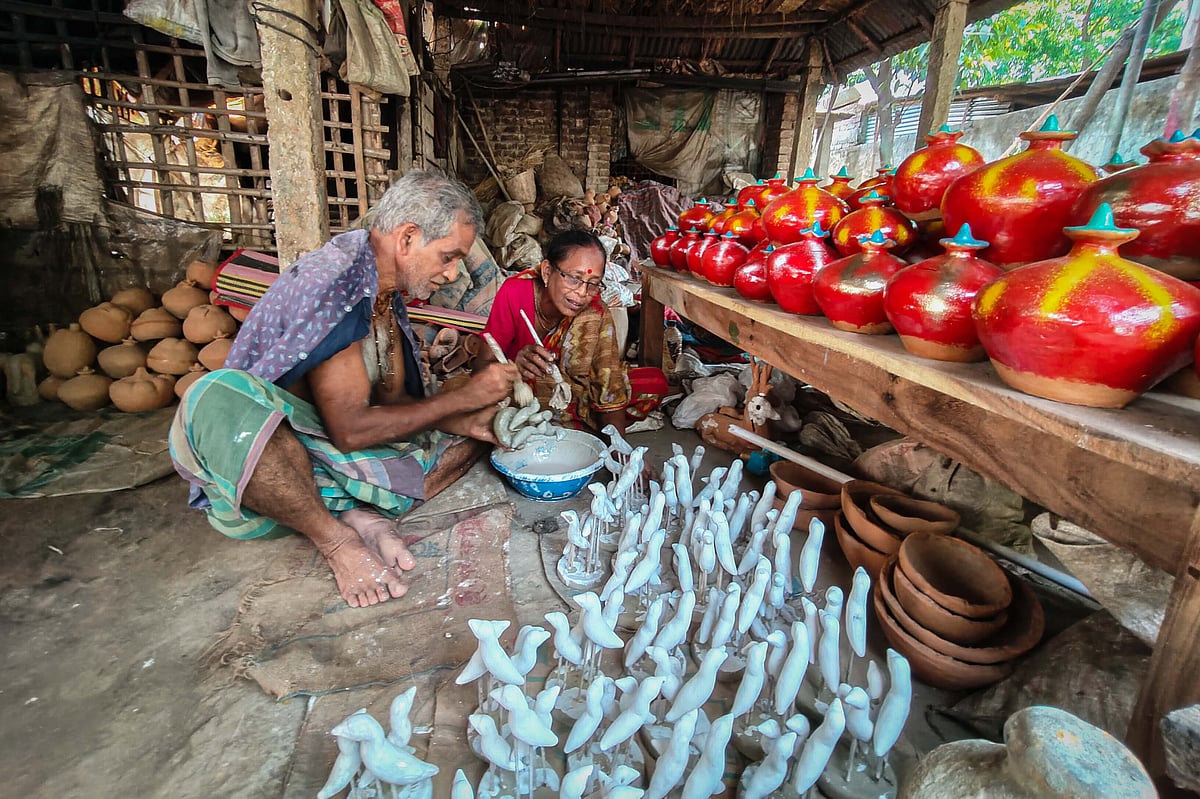 মাটির খেলনা রং করায় ব্যস্ত এই দম্পতি 