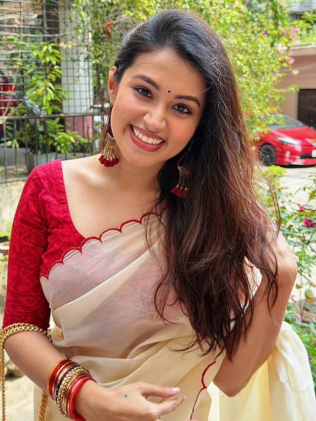 ঘিয়ে রঙের শাড়িতে লাল কার্ভড বর্ডার। সঙ্গে লাল ব্লাউজ আর ছোট কালো টিপ পরেছেন তাসনিয়া ফারিণ। সঙ্গে চুড়ি আর ঝুমকা