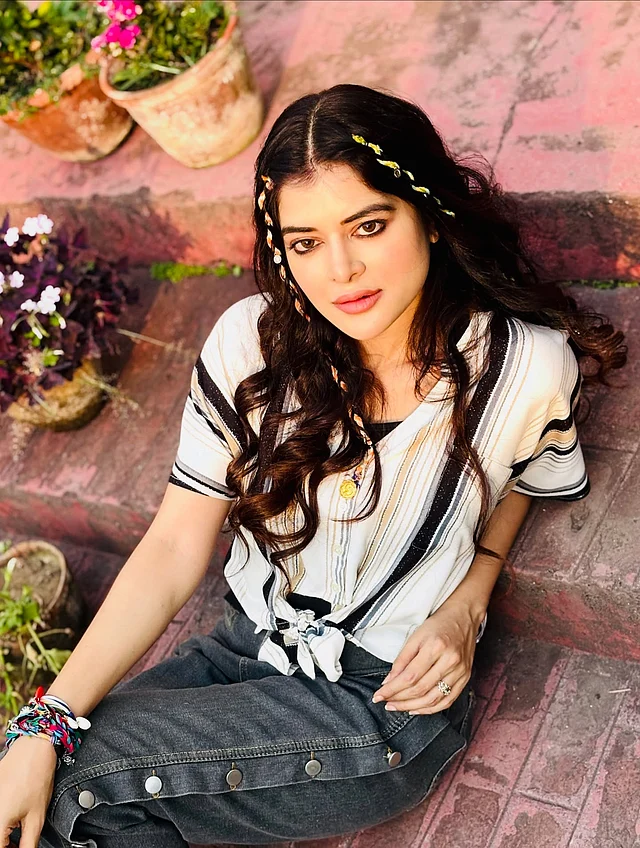 এই লুকে মধুমিতার হেয়ারস্টাইলটি একেবারেই ন্যাচারাল, বোহো-চিক ধাঁচের। ঢেউখেলানো চুলের সঙ্গে এই ছোট ডিটেইলিংই হয়ে উঠেছে মূল আকর্ষণ।  চুল মাঝখান দিয়ে সিঁথি করে দুই পাশে ভাগ করা হয়েছে। এরপর পুরো চুলে হালকা কার্ল করে সামনে দুই পাশে ছোট ছোট থিন ব্রেইড (পাতলা বেণি) করা হয়েছে। এই বেণিগুলোতে রঙিন সুতা আর চার্মস,  বিডস যোগ করা হয়েছে। বন্ধুদের সঙ্গে ডে-আউট, ফেস্টিভ লুক, কিংবা পার্টি—সব জায়গাতেই এটি মানানসই। 