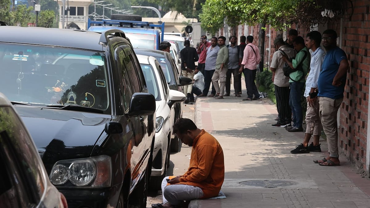 তেজগাঁওয়ের ট্রাস্ট ফিলিং স্টেশনে লাইনে থাকা চালকদের কেউ কেউ গাড়ি রেখে ফুটপাতে গাছের ছায়ায়