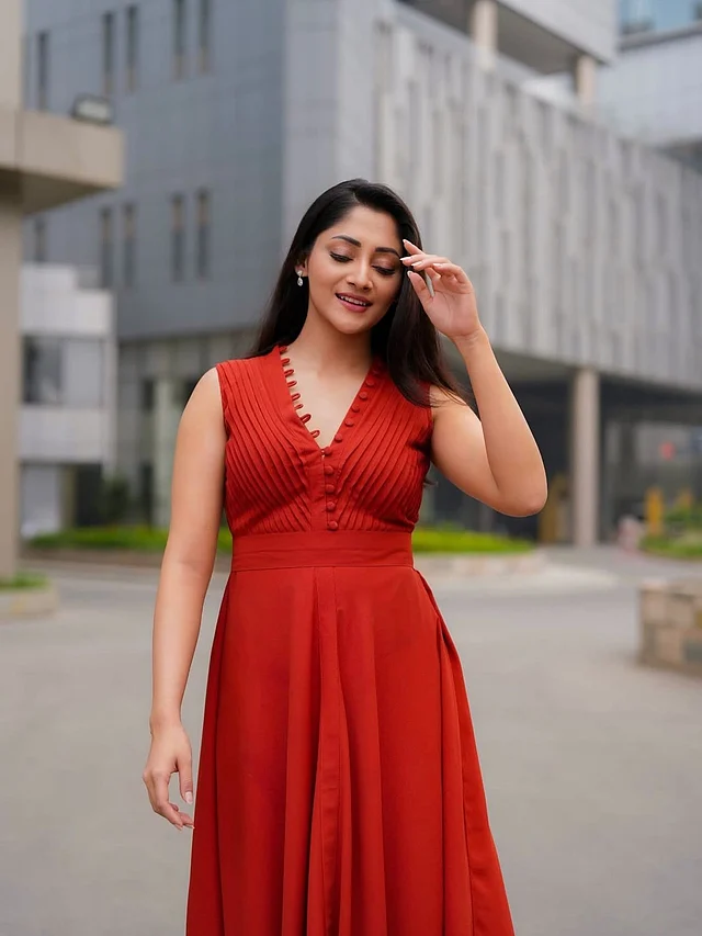 পূজা চেরি ধরা দিয়েছেন একটি স্টাইলিশ স্লিভলেস কাট লাল মিডি ড্রেসে। 