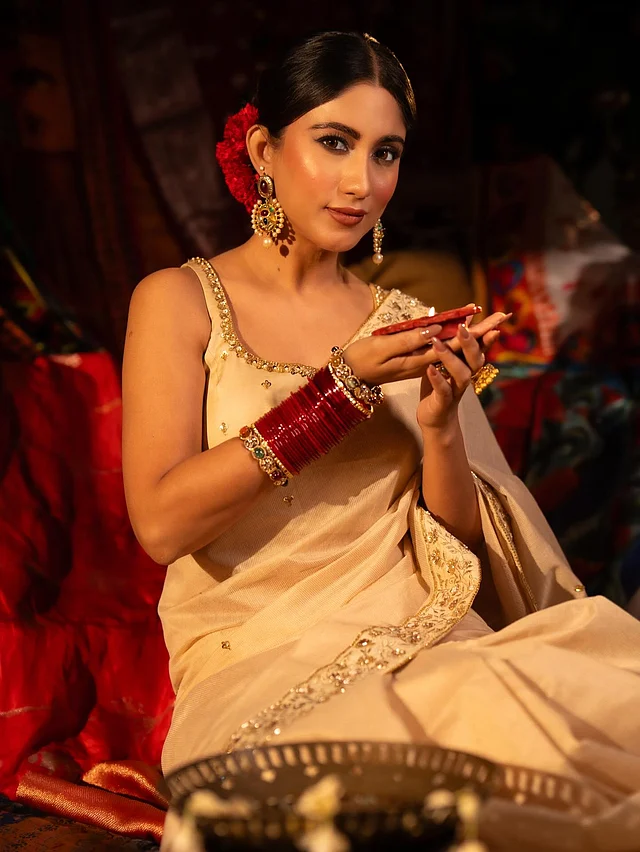 শাড়ির সঙ্গে আকর্ষণীয় বৈপরীত্য এসেছে লাল গোলাপ আর লাল চুড়িতে। 