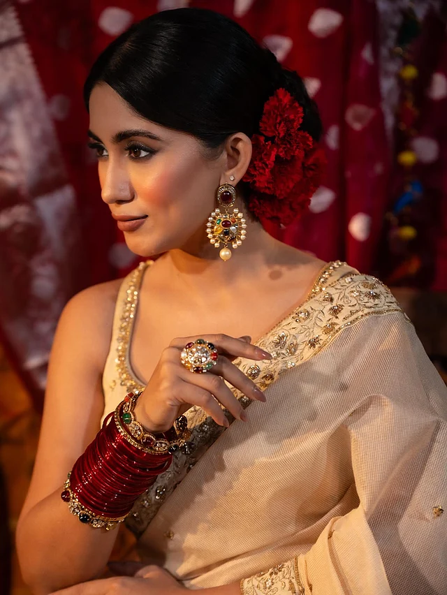 টেনে বাঁধা স্লিক আপডু আর নজরকাড়া ঝোলানো দুল ও স্টেটমেন্ট আংটির সঙ্গে গলা খালি রাখায় পারফেক্ট স্টাইলিং হয়েছে