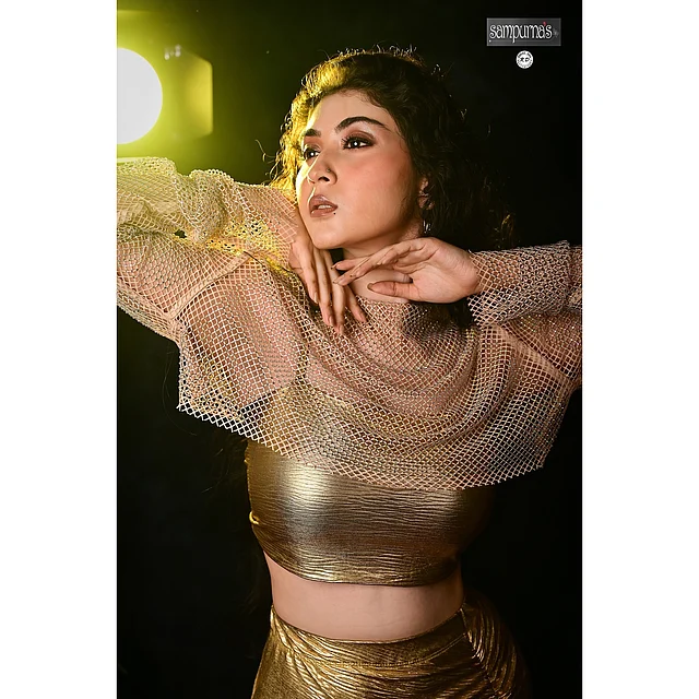 মেটালিক ফ্যাব্রিকের ক্রপ টপ পরেছেন সুন্দরী।  লেয়ারিং -এ যোগ হয়েছে নেট বা মেশ ওভারলে