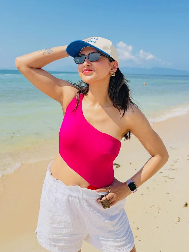 স্বচ্ছন্দ আর আত্মবিশ্বাসী উপস্থিতিতে তিনি যেন পুরো ফ্রেমটাই নিজের করে নিয়েছেন। পরনে হট পিঙ্ক ওয়ান-শোল্ডার টপ আর হাই-ওয়েস্টেড সাদা শর্টস। চোখে সানগ্লাস , মাথায় টুপি হয়েছে সঙ্গী