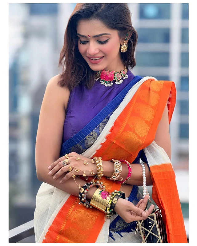 এর সঙ্গে গাঢ় ভায়োলেট হাই নেক স্লিভলেস ব্লাউজ পরেছেন তিনি