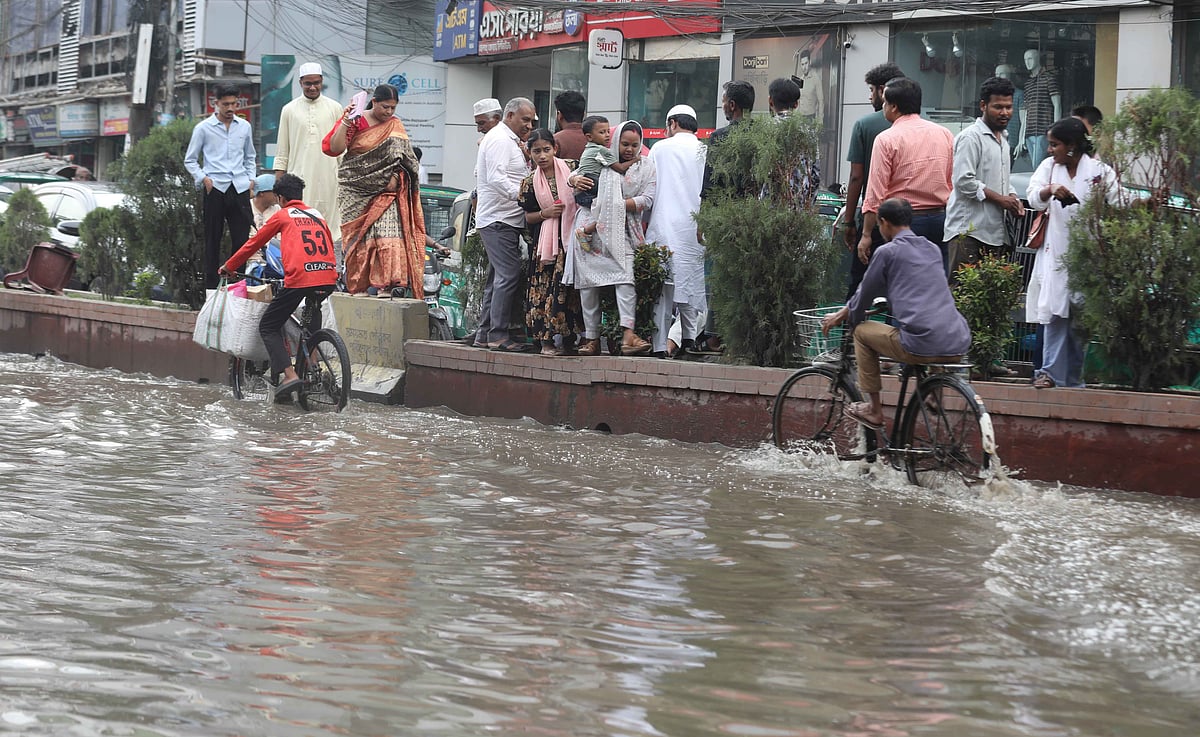 চট্টগ্রাম নগরের প্রবর্তক মোড়ে সড়কে পানি, তাই সড়ক বিভাজক দিয়েছে চলাচল করতে হচ্ছে পথচারীদের