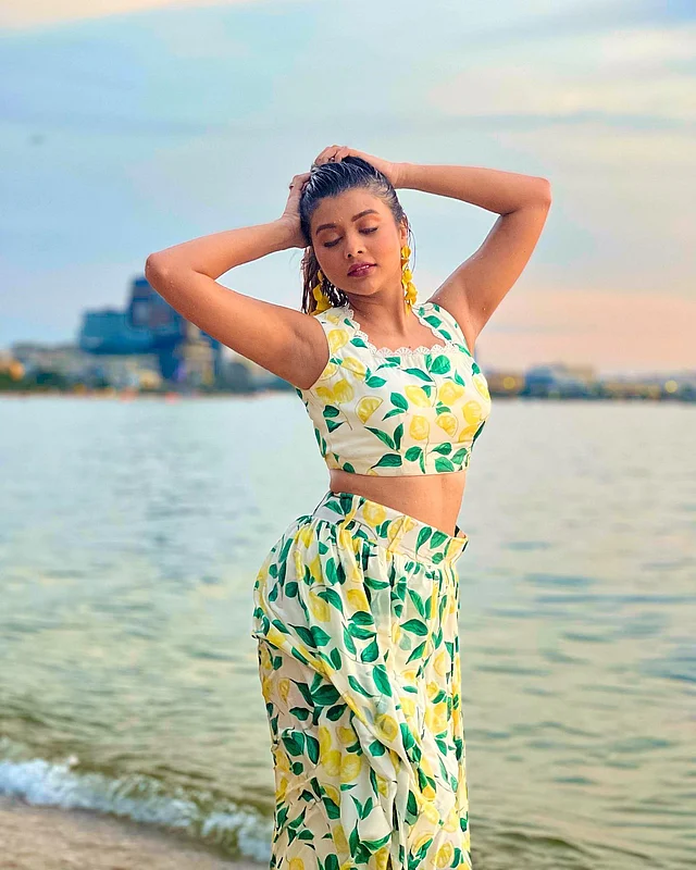 এখানে ম্যাচিং হলুদ সবুজ ছাপার সাদা ক্রপ টপ ও স্কার্টে দেখা যাচ্ছে তাঁকে 