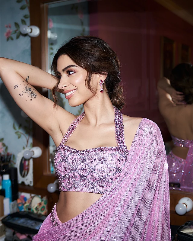 স্টাইলিশ জেন-জি তারকা খুশি কাপুর তাঁর সামার লুকে বেছে নিয়েছেন ক্রিস্টাল এমবেলিশমেন্টে সাজানো পিঙ্ক প্রি-ড্রেপড শাড়ি। হল্টার-নেক ব্লাউজ পুরো লুককে দিয়েছে সাহসী গ্ল্যাম ।  সামার স্টেটমেন্টকে আরও নজরকাড়া  সঙ্গে পরেছেন রুবি ও হিরার দুল ।